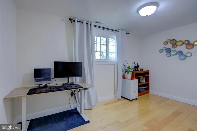 a view of workspace with wooden floor and cabinet