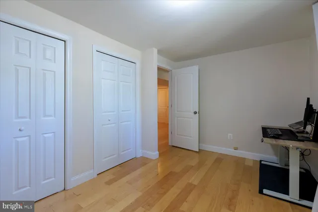 a view of empty room with a fireplace and wooden floor
