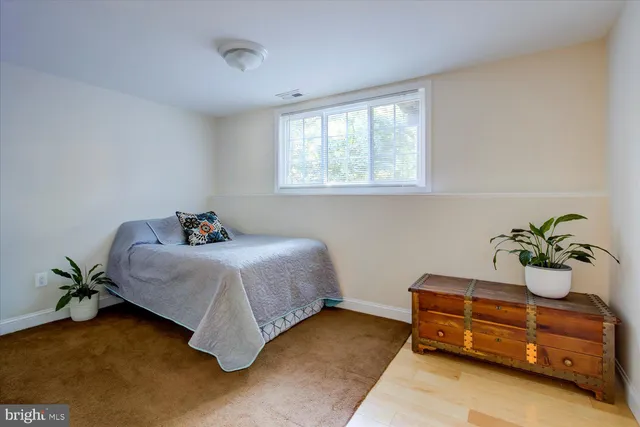 a bedroom with a bed and a potted plant