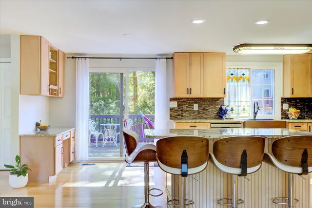 a kitchen with a stove a sink and a dining table next to a window