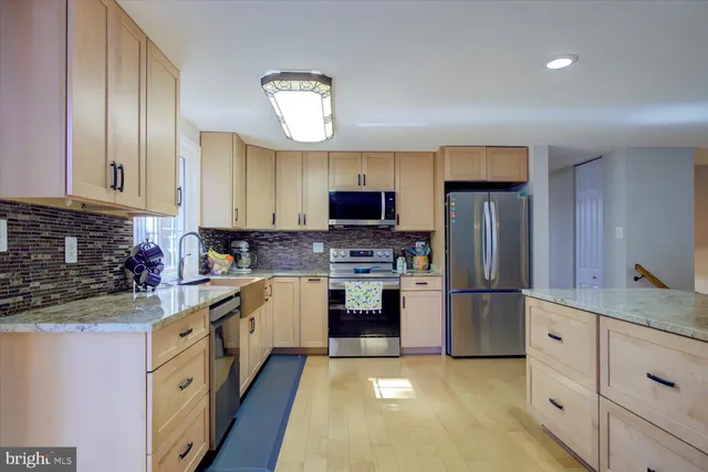 a kitchen with stainless steel appliances granite countertop a refrigerator stove and sink
