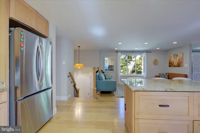 a view of kitchen with stainless steel appliances granite countertop refrigerator and a sink