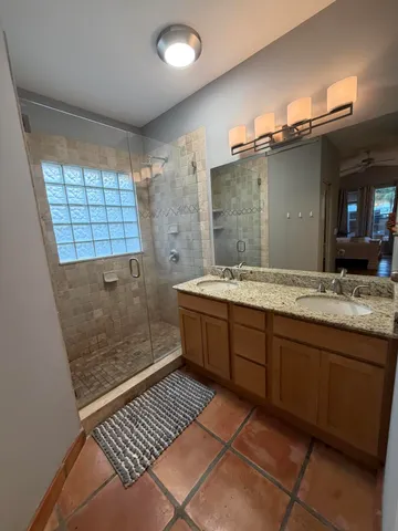a bathroom with a sink a large mirror and a shower