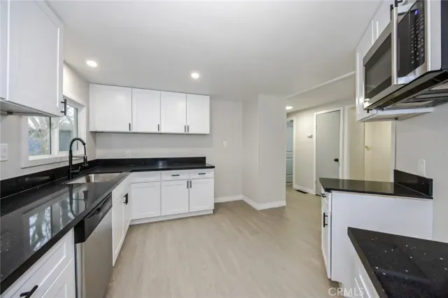 a kitchen with granite countertop a stove and a sink