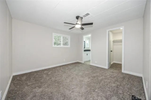 an empty room with fan and windows