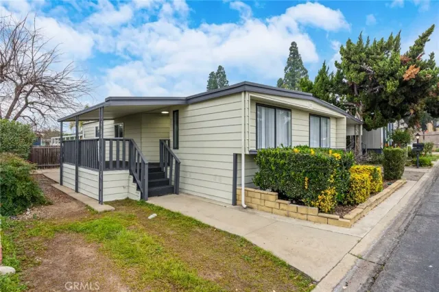 a view of a house with a yard and potted plants