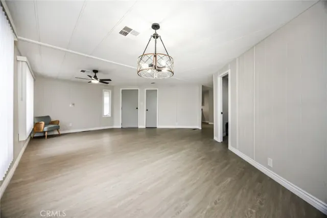 a view of a livingroom with wooden floor and a ceiling fan
