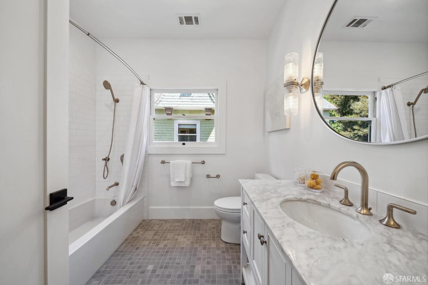 2518 Etna Street Berkeley, CA 94704 - Photo 56 of 99 a bathroom with a granite countertop sink a toilet a mirror a vanity and shower