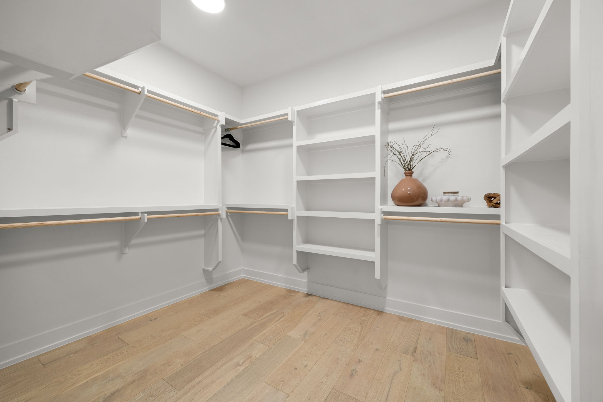 2524 Doc Reeves Street Austin, TX 78723 - Photo 19 of 36 Custom built-in shelving and warm wood floors elevate this organized walk-in closet space.