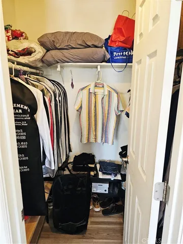 a view of walk in closet with clothes and shoes