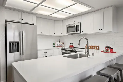 a kitchen with stainless steel appliances a refrigerator sink microwave and cabinets
