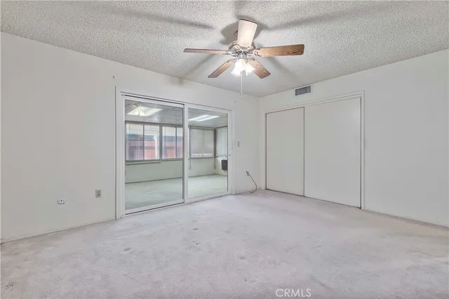 an empty room with closet and windows