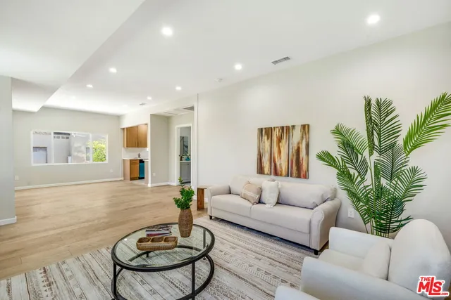 a living room with furniture potted plant and a large window
