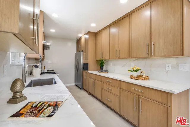 a kitchen with sink refrigerator and stove