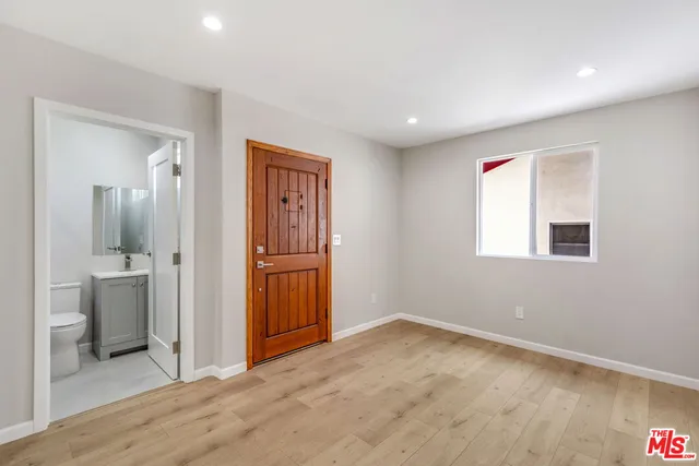 an empty room with a bathroom and mirror