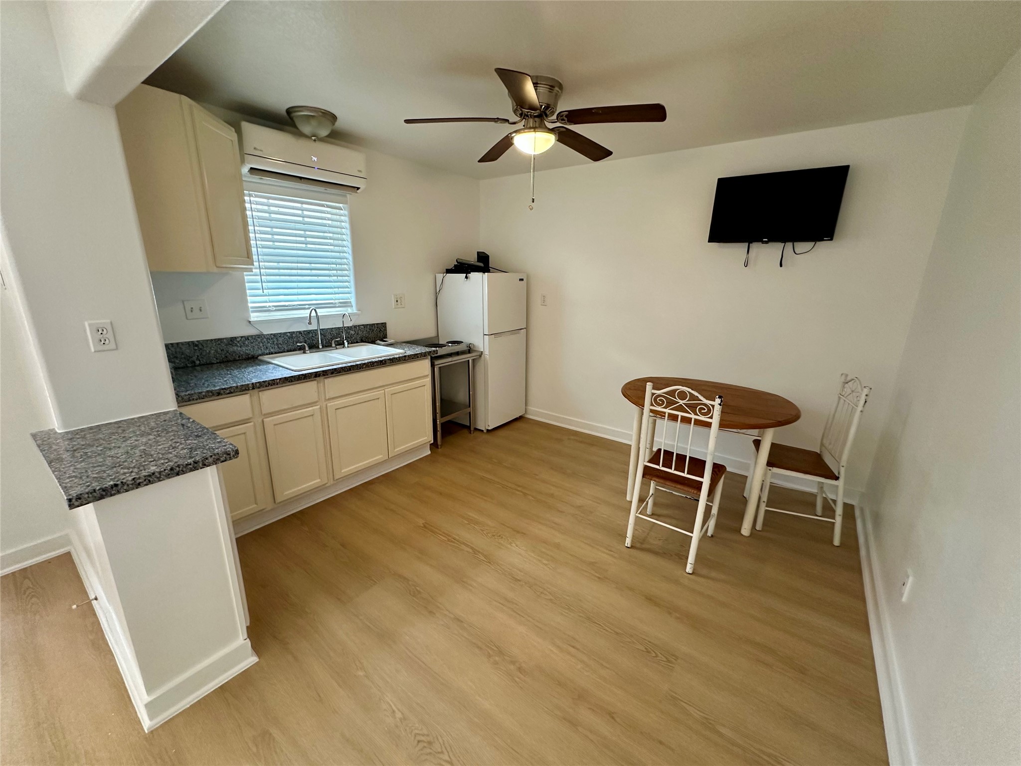 305 Miles Road Bacliff, TX 77518 - Photo 4 of 17 a kitchen with stainless steel appliances granite countertop a stove top oven a sink a dining table and chairs with wooden floor