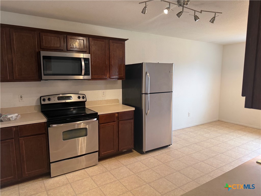 404 Blayton Street Troy, TX 76579 - Photo 12 of 30 a kitchen with a refrigerator stove and microwave