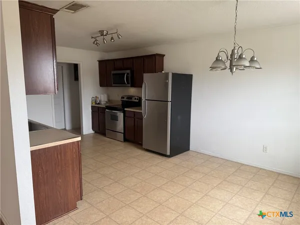 a kitchen with stainless steel appliances a refrigerator and a stove top oven