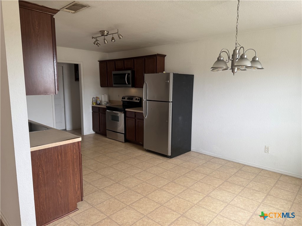 404 Blayton Street Troy, TX 76579 - Photo 15 of 30 a kitchen with stainless steel appliances a refrigerator and a stove top oven
