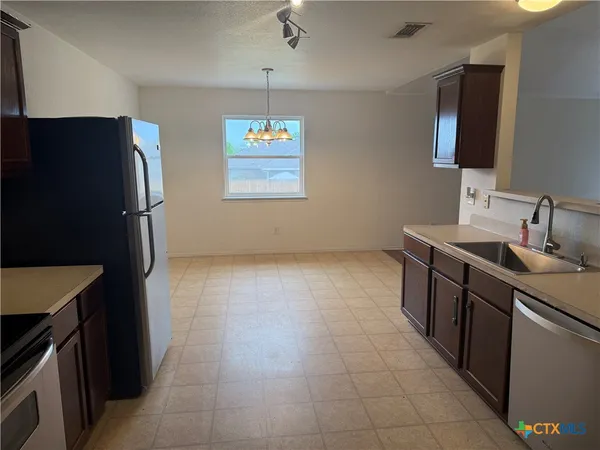 a kitchen with stainless steel appliances granite countertop a refrigerator and a sink