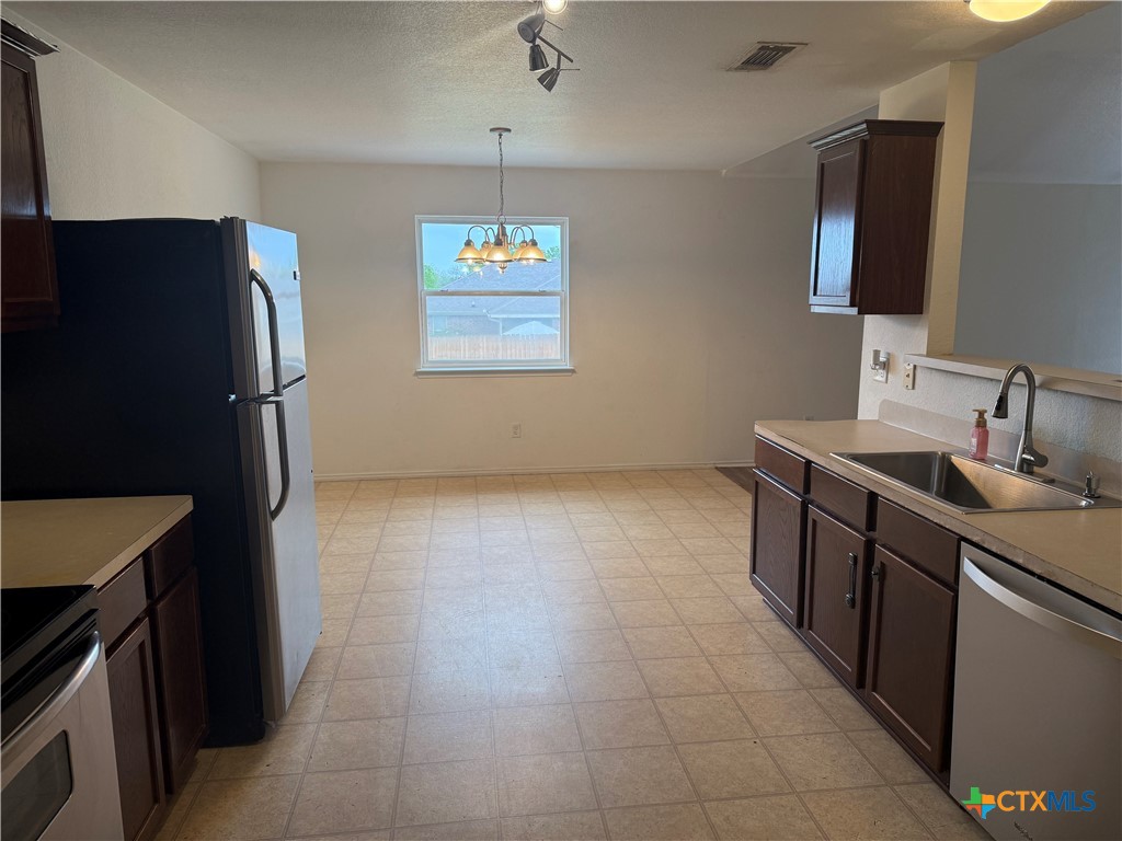 404 Blayton Street Troy, TX 76579 - Photo 16 of 30 a kitchen with stainless steel appliances granite countertop a refrigerator and a sink
