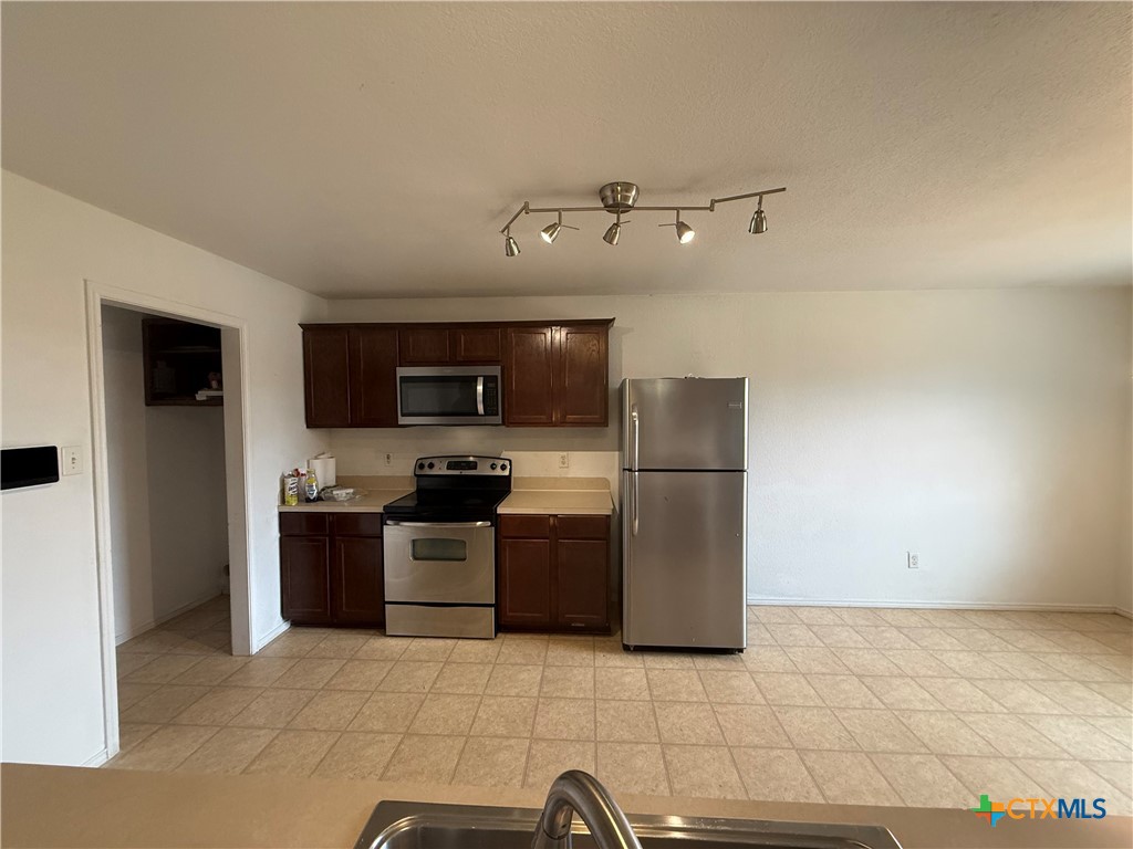 404 Blayton Street Troy, TX 76579 - Photo 10 of 30 a kitchen with stainless steel appliances granite countertop a refrigerator and a stove top oven