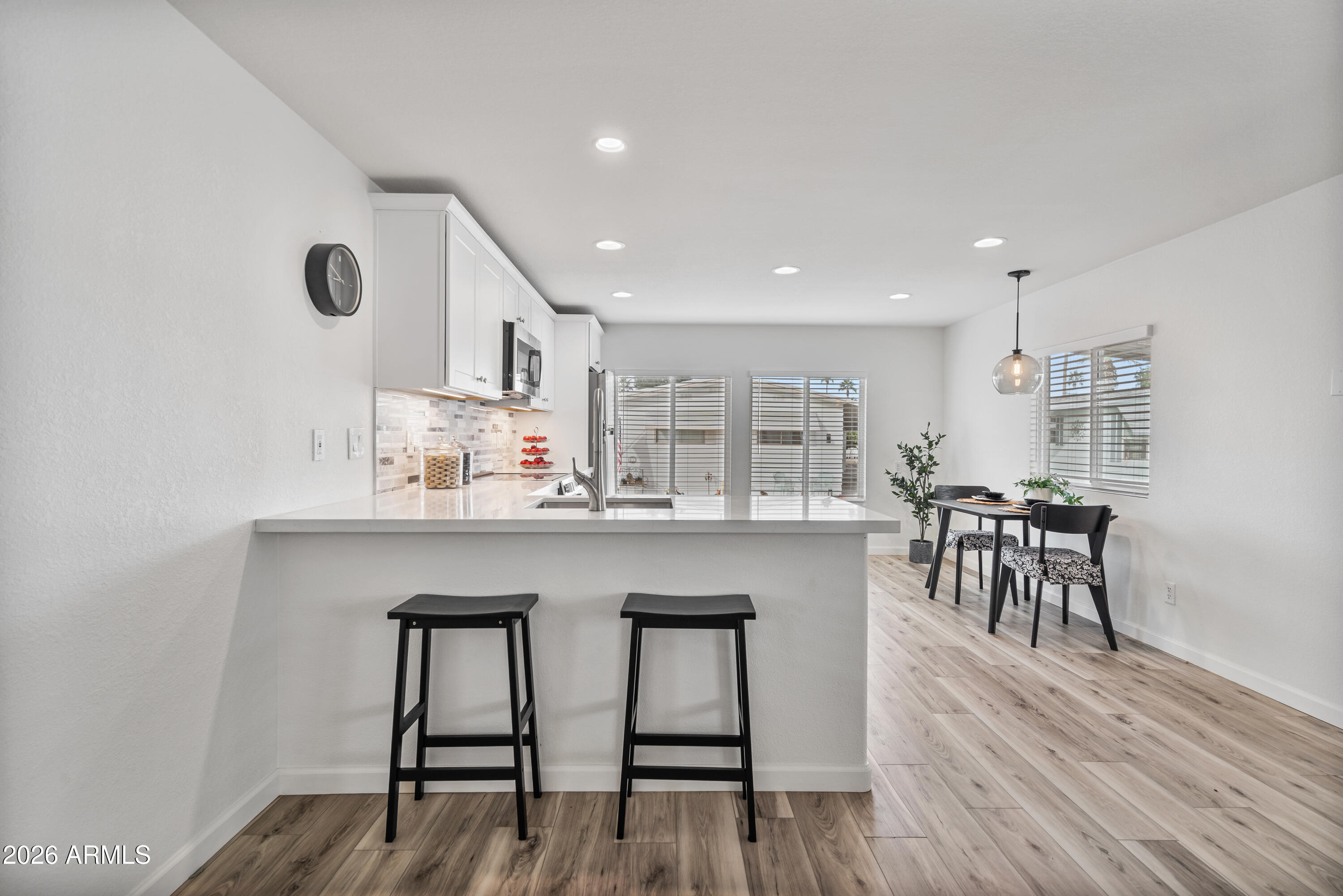 205 South Higley Road, Unit 52 Mesa, AZ 85206 - Photo 13 of 34 a kitchen with table chairs cabinets and wooden floor