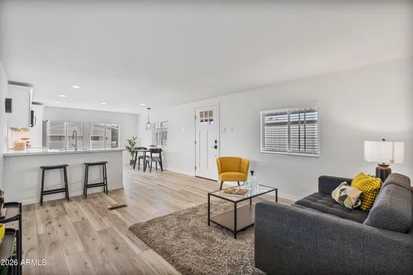 a kitchen with stainless steel appliances a white table chairs and wooden floor
