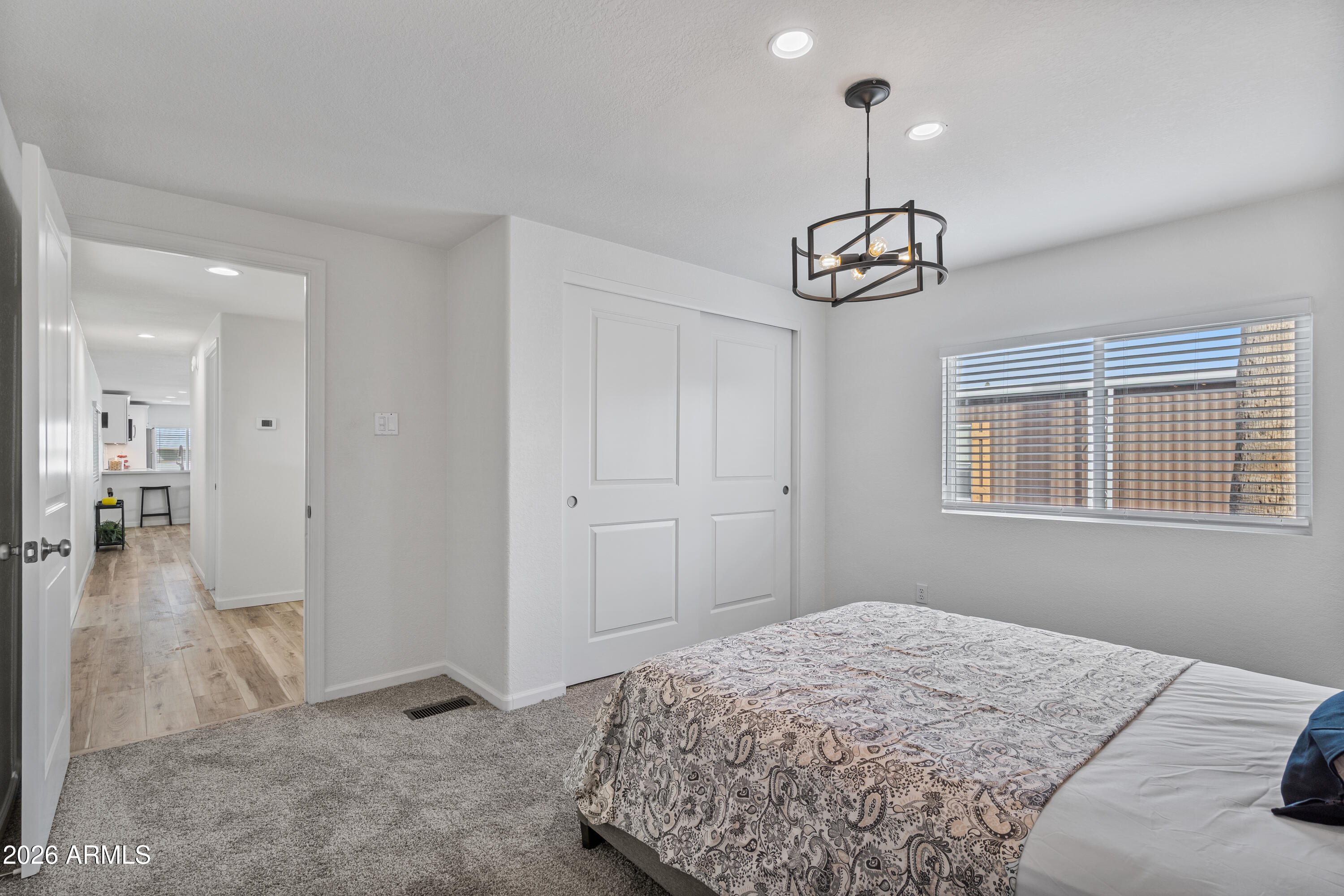 205 South Higley Road, Unit 52 Mesa, AZ 85206 - Photo 23 of 34 a bedroom with a bed and chandelier