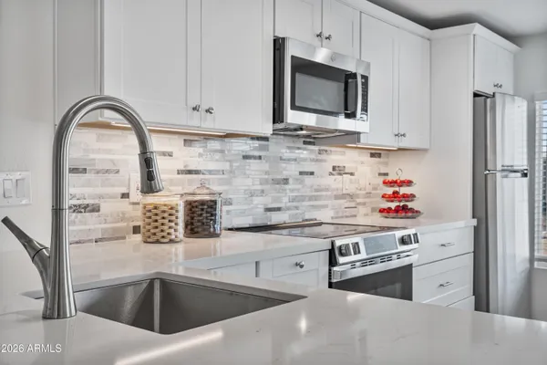 a kitchen with stainless steel appliances granite countertop a sink and a microwave