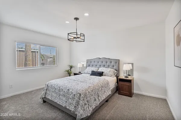 a bedroom with a bed and potted plant on dresser