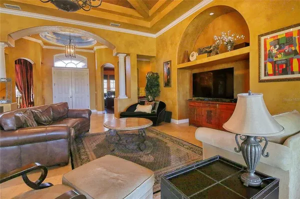 a living room with furniture a chandelier and a large window