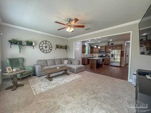 a living room with furniture and a view of kitchen