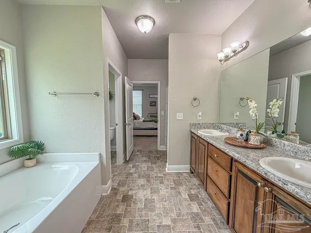 a spacious bathroom with a granite countertop tub sink and mirror