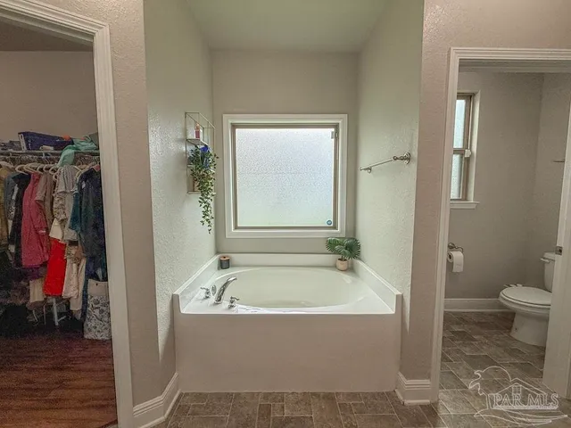 a spacious bathroom with a bathtub and a toilet