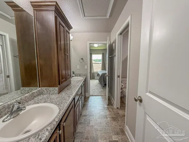a bathroom with a granite countertop sink a mirror and a bathtub