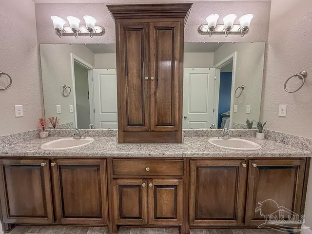 a bathroom with a granite countertop sink a mirror and a vanity