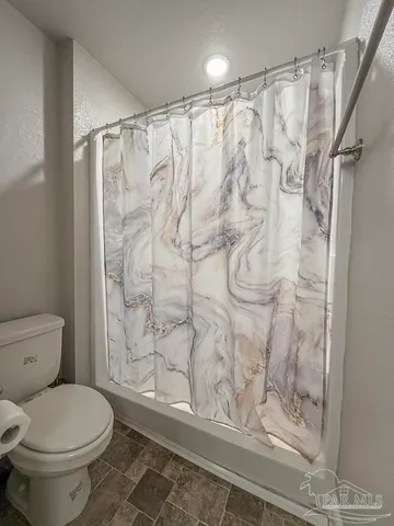 a bathroom with a toilet and shower