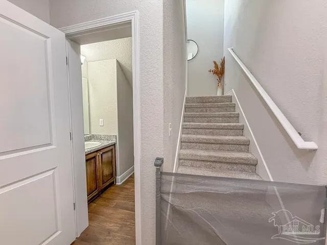 a view of a hallway with wooden floor and staircase