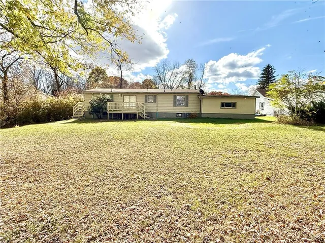 a front view of a house with a yard and lake view