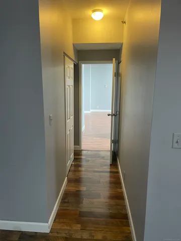 a view of a hallway with wooden floor