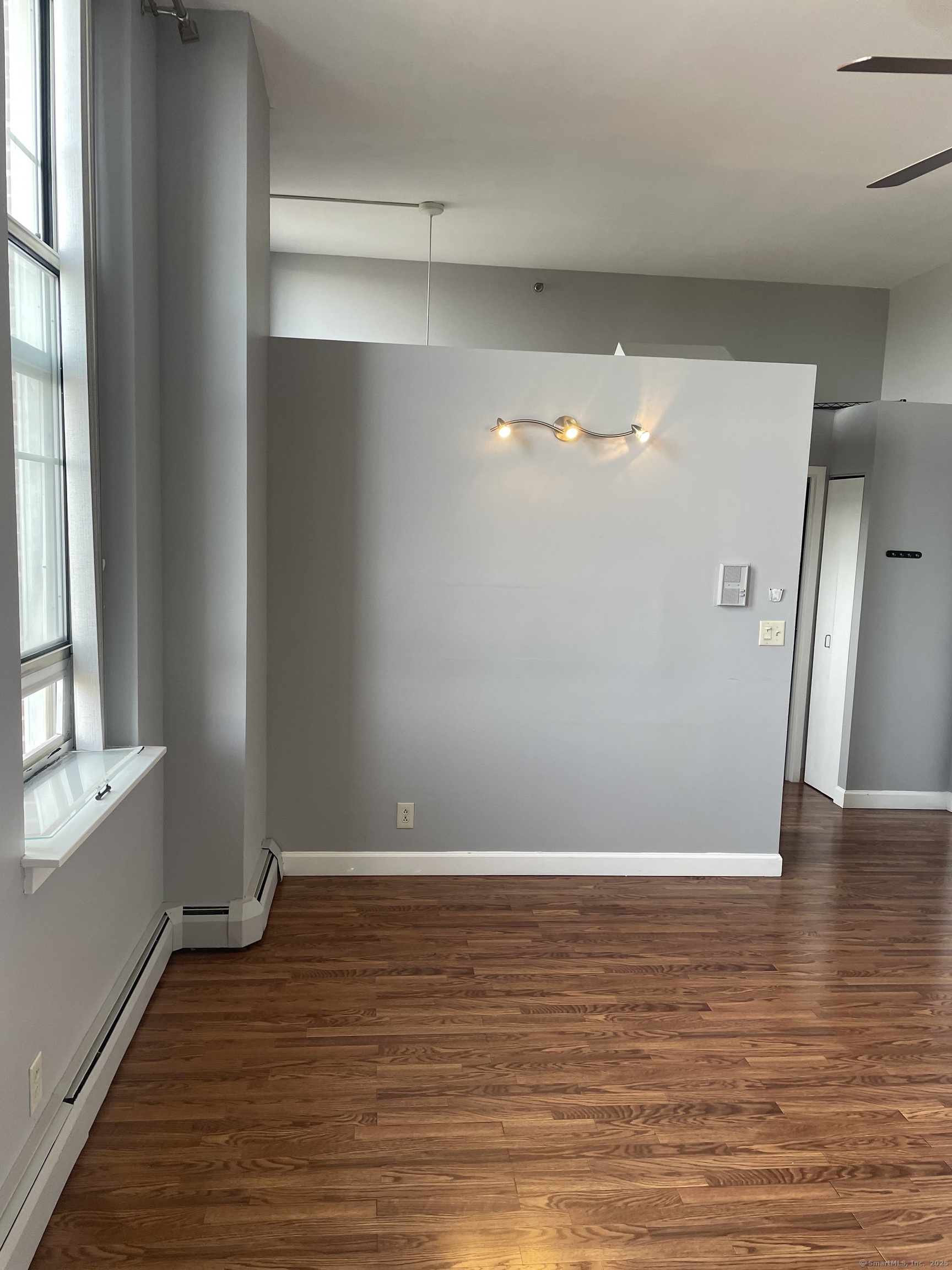 124 Court Street, Unit 1103 New Haven, CT 06511 - Photo 3 of 21 a view of an empty room with wooden floor and a window