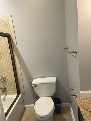 a white toilet sitting next to a tub