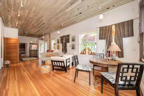 a dining room with furniture window and wooden floor
