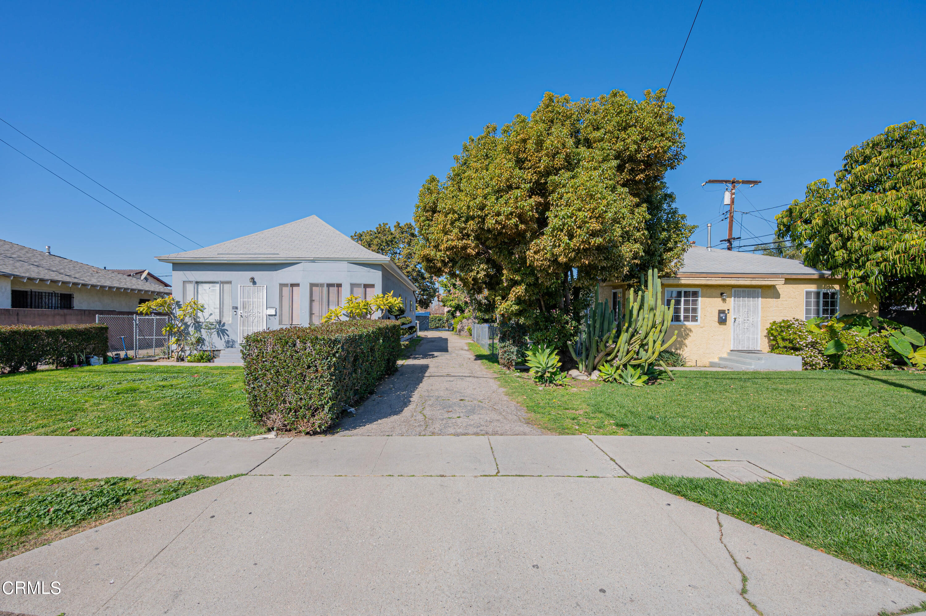 9911 Tweedy Lane Downey, CA 90240 - Photo 1 of 28 a front view of a house with a garden and yard