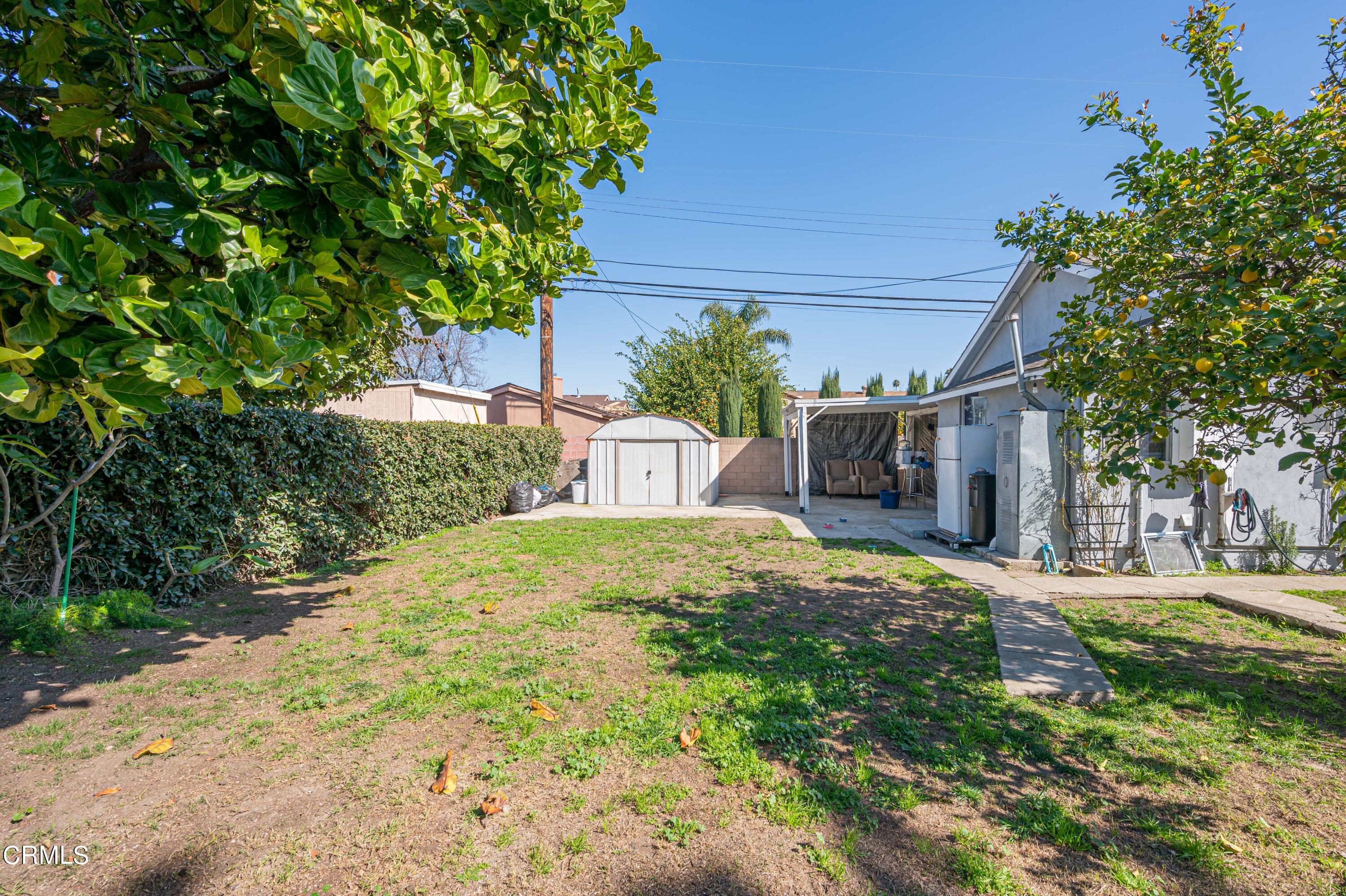 9911 Tweedy Lane Downey, CA 90240 - Photo 14 of 28 a yellow house with trees in front of it