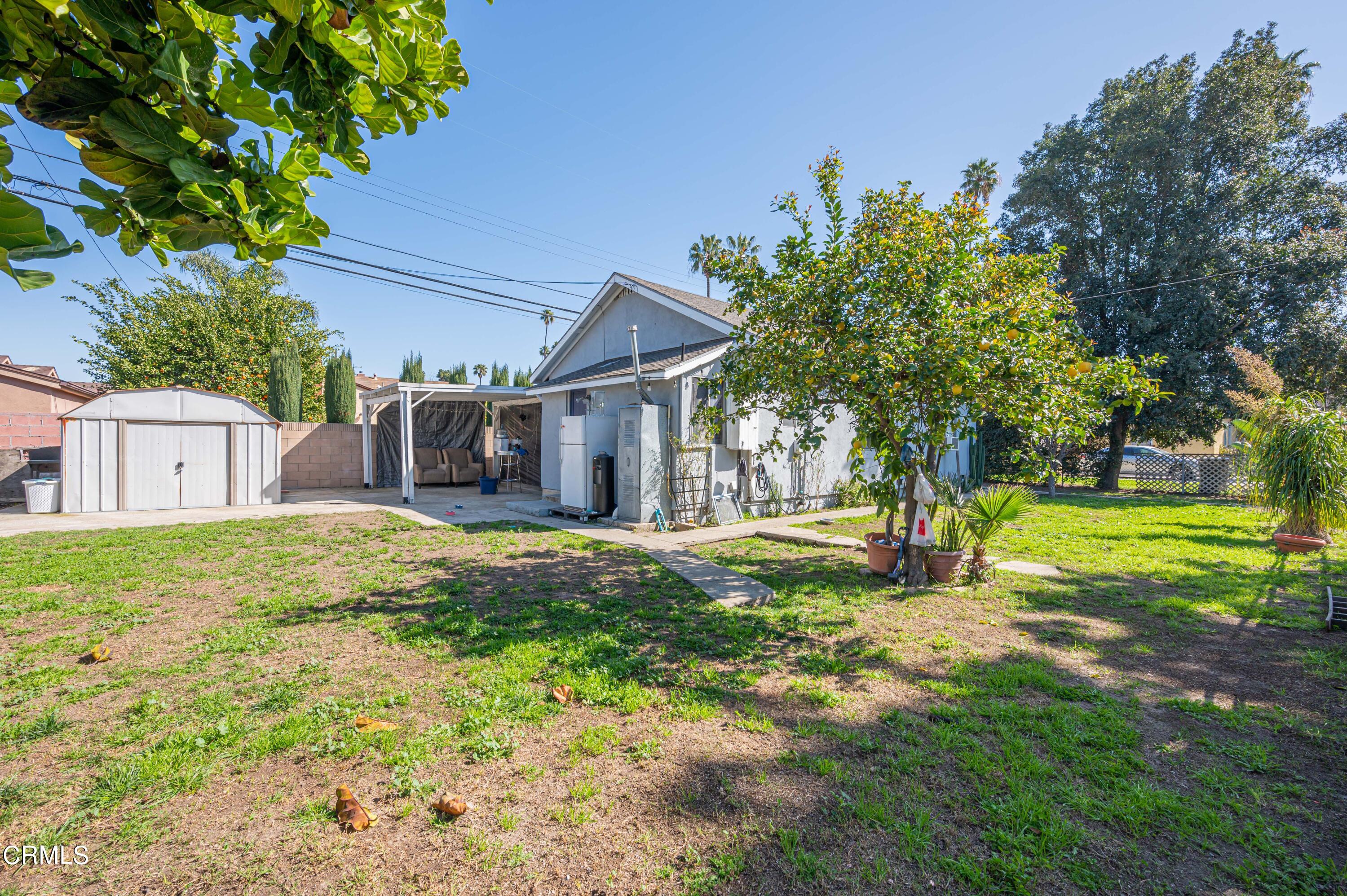 9911 Tweedy Lane Downey, CA 90240 - Photo 16 of 28 a view of a house with a small yard and a large tree