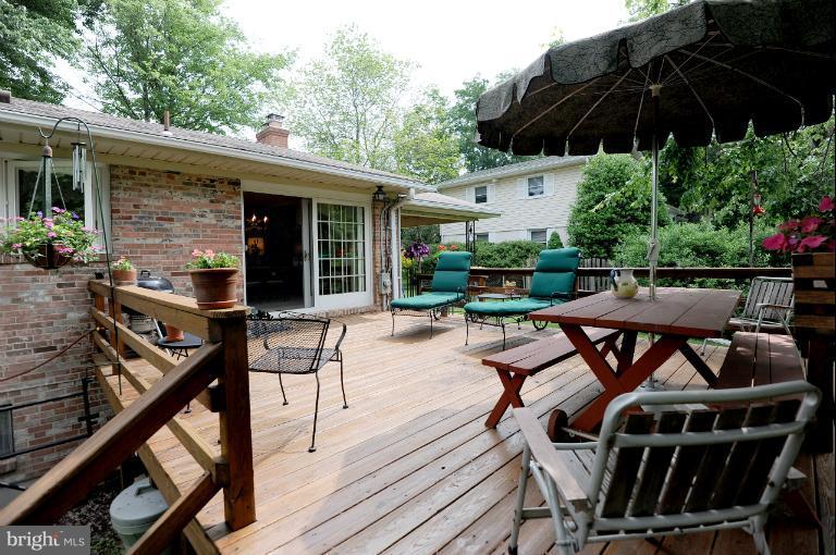 6505 Divine Street McLean, VA 22101 - Photo 25 of 26 a view of a patio with table and chairs under an umbrella with wooden floor
