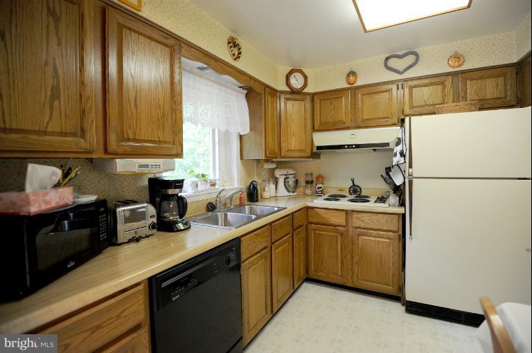 6505 Divine Street McLean, VA 22101 - Photo 7 of 26 a kitchen with stainless steel appliances granite countertop a sink stove and refrigerator