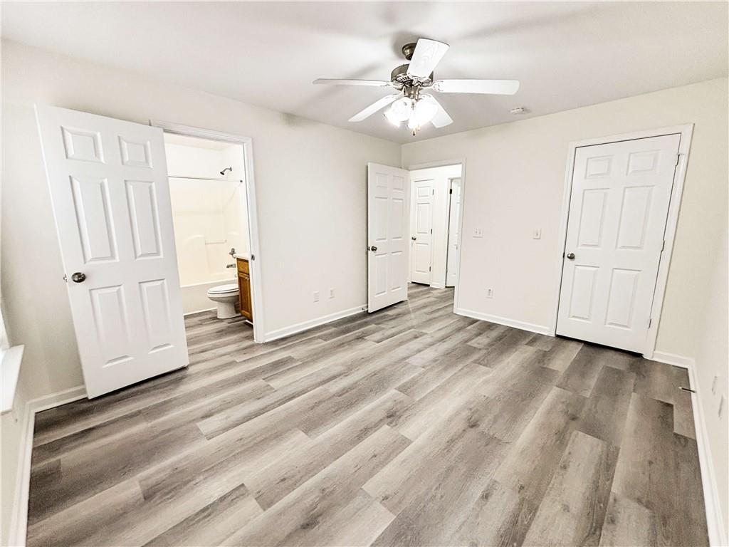 1400 Stonehaven Circle, Unit 1402 Cartersville, GA 30121 - Photo 11 of 23 an empty room with wooden floor and ceiling fan